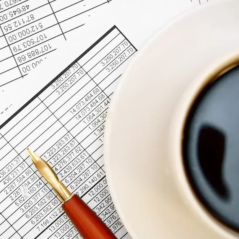 Buchhaltungsunterlagen mit Stift und Kaffee auf einem Schreibtisch