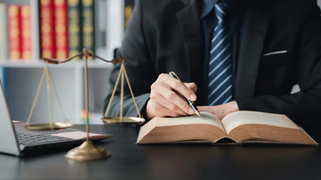 Steuerstrafrecht Anwalt am Schreibtisch mit Gesetzbuch und Waage – rechtliche Beratung und Verteidigung im Steuerstrafverfahren